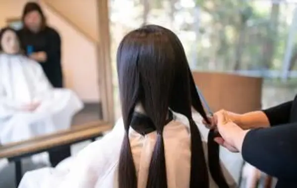 寄付のために髪を切り分けて切る女性