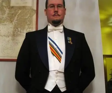 Mężczyzna ubrany w biały smoking z dekoracjami