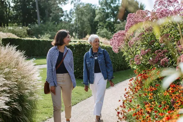 Two people walking along a garden path at RHS Wisley