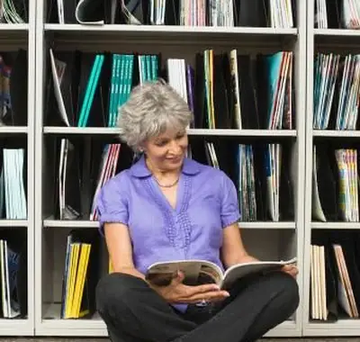 Mulher lendo revista na biblioteca
