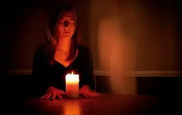 Mulher fazendo sessão espírita sozinha