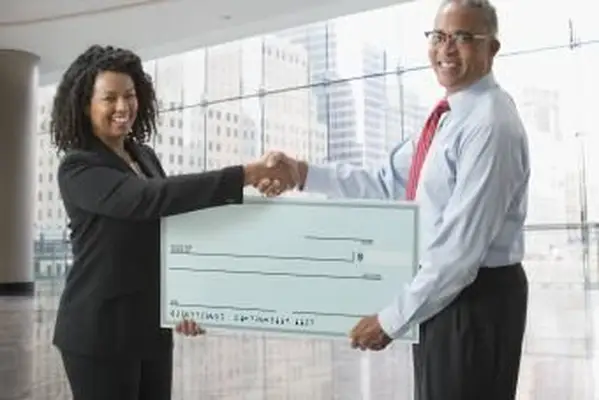 特大の空白のチェックを保持しているビジネスの女性と男性