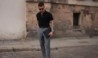 Muž na sobě šedé kalhoty a polo tričko