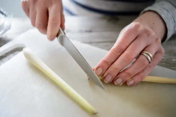 Slicing off the woody end using a sharp knife