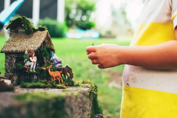 Child playing with fairy garden