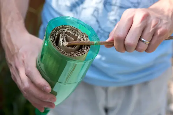 Inserting a stick through the two holes