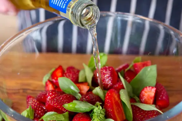 Pouring the cider vinegar over the strawberries