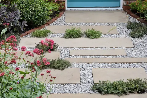 Garden path with plants growing between the slabs