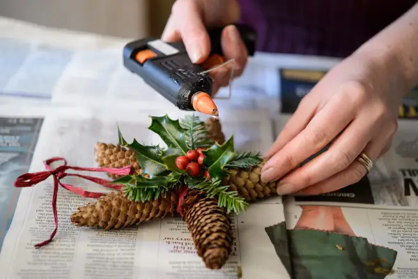 Gluing on the fir and holly sprigs