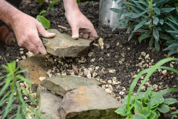 Laying flat stones on top of the gravel