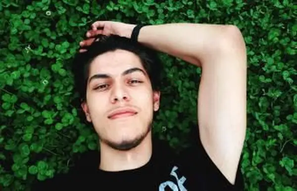 Adolescente deitado sobre plantas