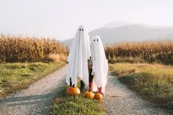 Kinder, die in weiße Laken gekleidet sind und wie niedliche Geister aussehen