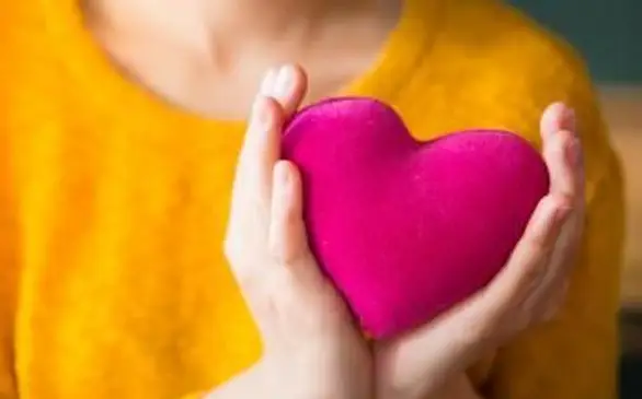 Teenager mit rosa Herzkissen