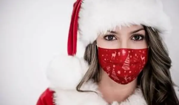 クリスマスのフェイスマスクを身に着けている女性のサンタ