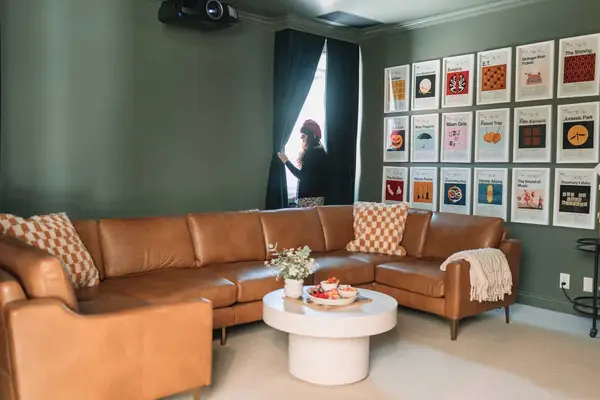 movie room with leather sectional and movie-themed wall art