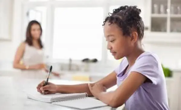 キッチンで食事日記を書く女の子