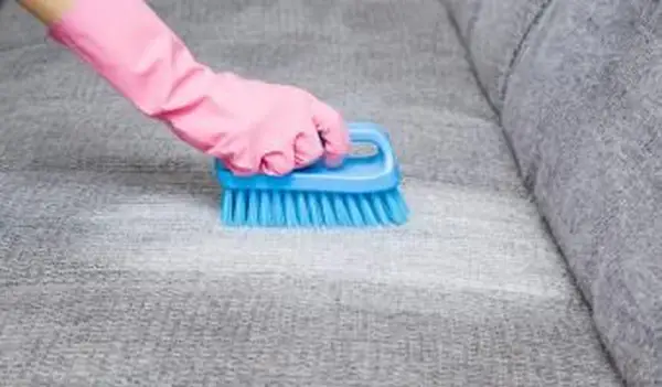 enlever la tache du canapé gris avec une brosse