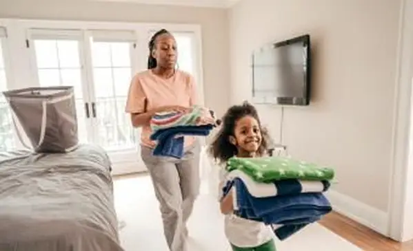 Figlia e madre piegano asciugamani puliti clean