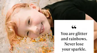 Růžovlasá dívka leží na velkém průsvitném plaveckém kruhu se zlatými flitry