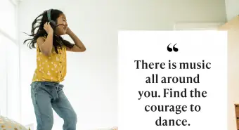 Mladá dívka pomocí sluchátek a tančí na posteli