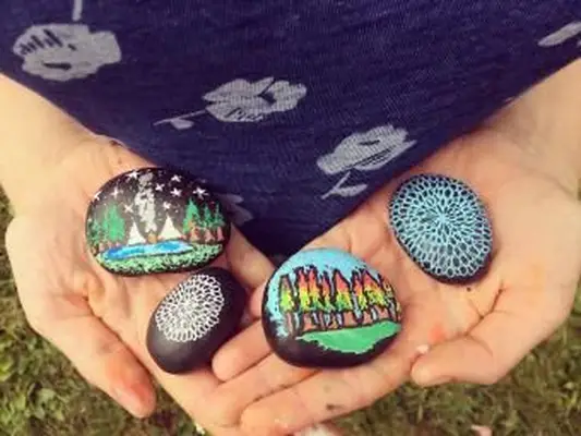 אוחז בידיים סלעים צבועים