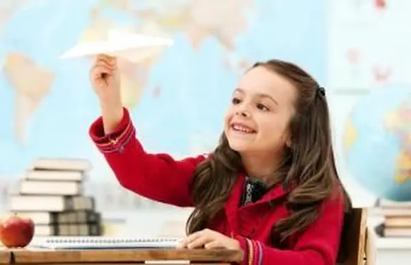 Menina olhando para o avião de papel