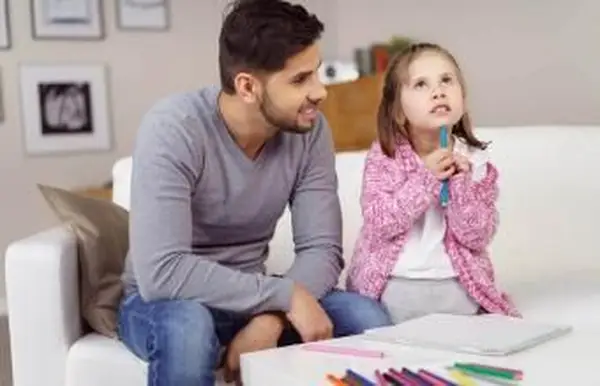 אבא יושב עם ילד תוך כדי צביעה