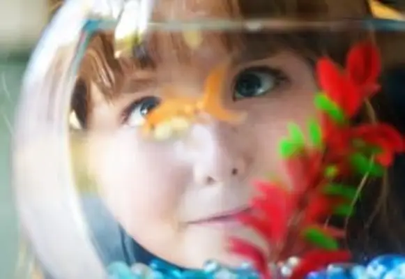 ragazza che guarda il pesce rosso