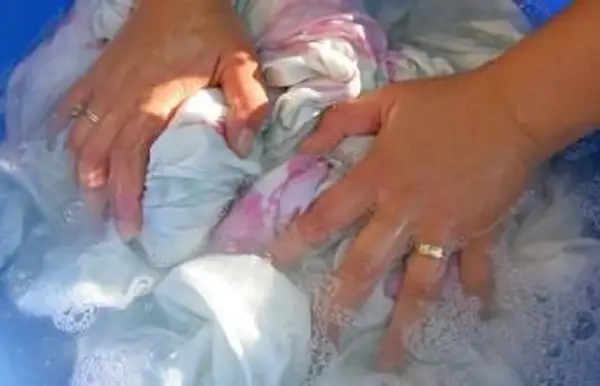 Žena ruky pranie oblečenia