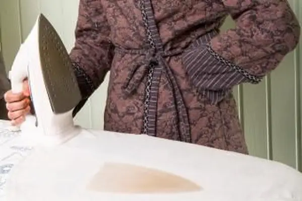 焦げたシャツの横にアイロンを持っている