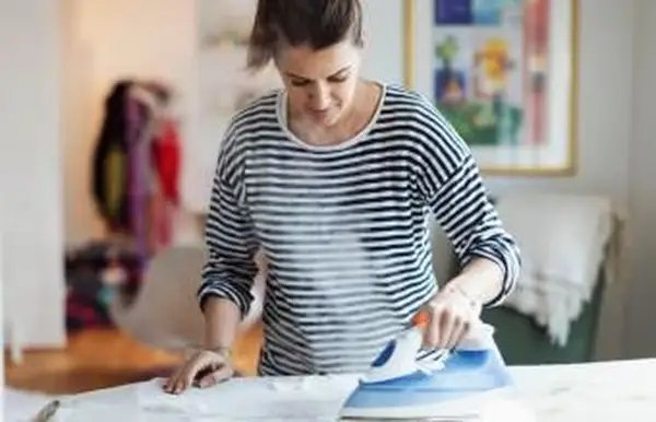 אישה בד מגהץ בבית