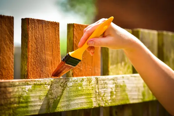 Painting a fence. Getty Images.