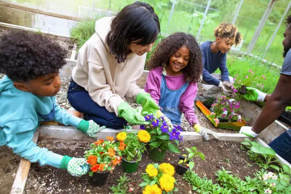 Children planting flowers in a raised bed. Getty Images