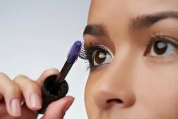 senhora aplicando sombra com pincel