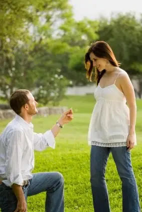 Mężczyzna oświadczający się na zgiętym kolanie