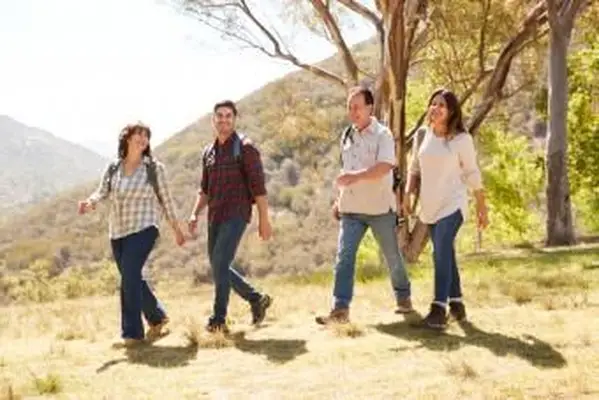 Pareja y padres senior sonriendo durante un paseo por la montaña