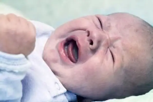 Nouveau-né allongé sur le dos pleurant