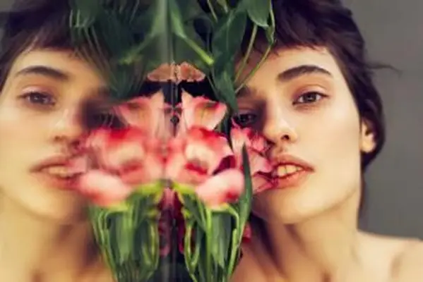 Junge nachdenkliche Frau spiegelt sich im Spiegel