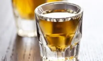 Trois verres à liqueur pleins de whisky sur une table de bar