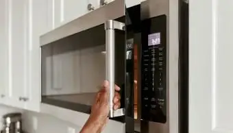 Donna che apre un forno a microonde