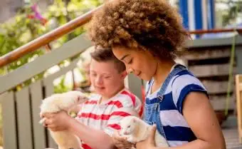 Duas crianças segurando furões