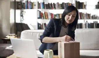 Mulher escrevendo em uma caixa