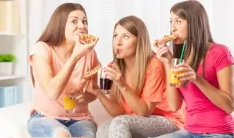Adolescentes comendo pizza