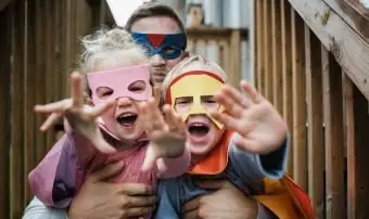 スーパーヒーローの衣装を着た父親と子供の肖像画