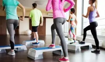 Personnes travaillant avec des steppers dans une salle de sport