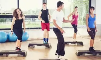 Groupe de personnes faisant de l'aérobic étape dans la salle de sport
