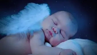 bambino con le ali che dorme nel letto