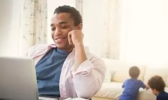 mężczyzna używający laptopa w salonie