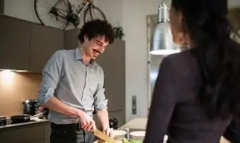 그의 아내 시계 동안 요리하는 남자