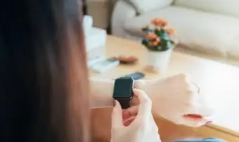 彼女の時計を見ている女性